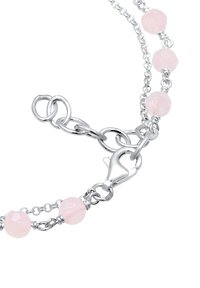 Silberne Kettenarmband mit rosa facettierten Perlen, einem Karabinerverschluss und miteinander verbundenen Ringen für eine verstellbare Länge.