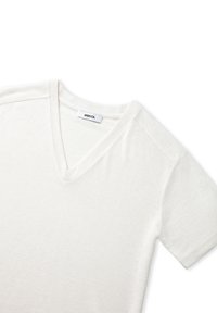 Witte V-hals t-shirt van zacht materiaal. Heeft korte mouwen en een eenvoudig ontwerp, met het merklabel zichtbaar bij de hals.