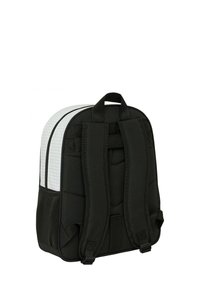 Zaino imbottito nero con un design strutturato, dotato di un pannello testurizzato bianco e spallacci regolabili. Tasche laterali in rete visibili.