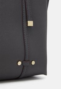 Czarna szara torebka syntetyczna z teksturowaną powierzchnią, złotymi detalami i ściegami. Zawiera zamek błyskawiczny i metkę z logo.