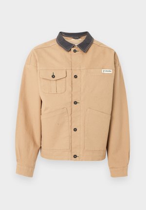 Ανοιχτό καφέ σακάκι με κουμπιά, μαύρο γιακά, τέσσερις μπροστινές τσέπες, εκ των οποίων η μία με κουμπί, και ετικέτα της μάρκας Columbia στο στήθος.