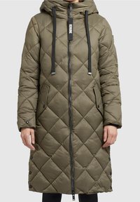 Quilted olive green long coat with a zip front, adjustable hood, black drawstrings, and side pockets, featuring snap buttons along the hem.