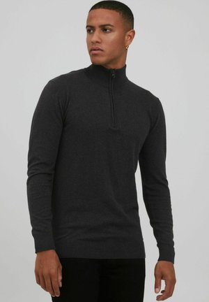 Sudadera de zip negro gris, hecha de un material de punto suave. Presenta un cuello alto, mangas largas y puños y dobladillo acanalados.
