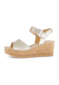 Gold platform sandals feature a textured, reptile-patterned strap, adjustable ankle buckle, and a layered cork-like wedge heel.