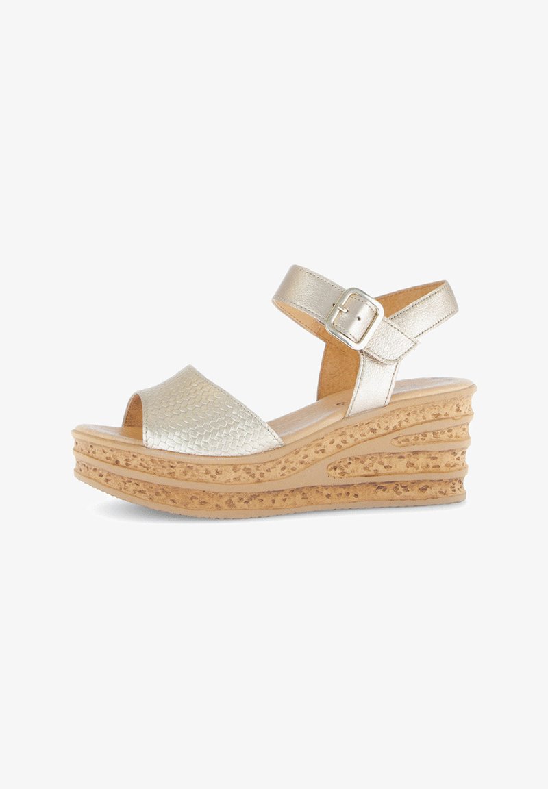 Gold platform sandals feature a textured, reptile-patterned strap, adjustable ankle buckle, and a layered cork-like wedge heel.