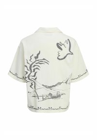 Vit kortärmad skjorta med en grå landskaps- och fågelillustration på baksidan, med en något texturerad tyg och platt krage.