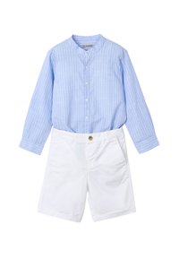 Camisa de manga larga a rayas azul claro con cuello mao, combinada con pantalones cortos blancos que tienen un botón frontal y bolsillos.