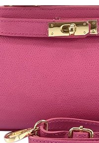 Sac en cuir texturé rose avec un fermoir doré. Dispose d'une sangle amovible. Design compact avec une finition lisse et un matériel minimal.