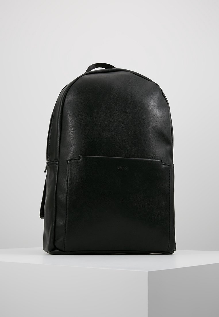 Zwarte leren rugzak met een gladde textuur, afgeronde bovenkant, voorzak met rits en een minimalistisch ontwerp. Stevige schouderbanden maken de look af.