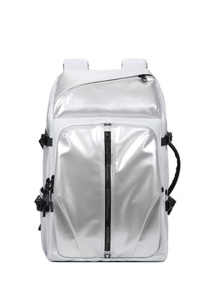 Zaino metallico argento con molte tasche con cerniera, cinturini laterali neri, spallacci imbottiti e dettaglio con cerniera verticale frontale.