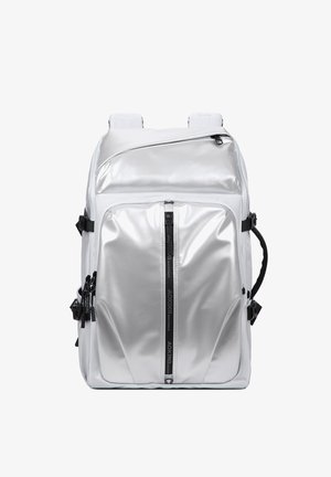 Silver metallic backpack with multiple zippered pockets, black side straps, padded shoulder straps, and a vertical front zipper detail.