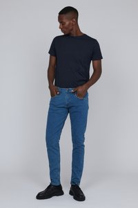 Camiseta navy combinada con jeans de mezclilla azul ajustados y zapatos negros, mostrando un estilo clásico casual y una textura suave.