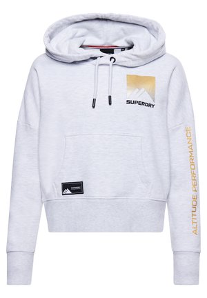 Sweat à capuche court gris clair avec poche avant, cordons réglables, texte doré "Altitude Performance" sur la manche, et logo Superdry sur la poitrine et la poche.
