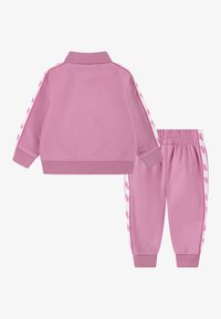 To-delt tracksuit i rosa, med en glidelåsjakke med ribbet krage og matchende bukser med logo-detaljer på siden og elastisk midje.