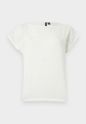 Hvit bluse med korte ermer og hullbroderidetaljer på øvre del av brystet og ermene, rund hals, lagt flatt på lys bakgrunn.