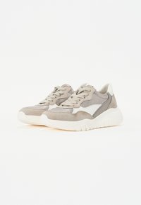 Lys grå sneakers med en blanding av semsket skinn og glatte materialer, med en hvit stripe, runde lisser og en tykk, teksturert såle.