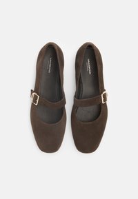 Ballerine in suede marrone con punta arrotondata e cinturino stile Mary Jane con dettaglio della fibbia in tonalità oro. Fodera interna liscia.