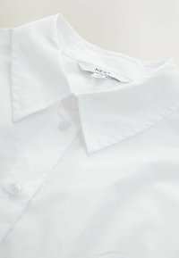 White collared shirt with a smooth texture, featuring a two-button closure and a neatly finished collar. Brand label visible.