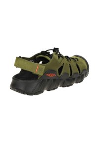 Green leather sandal with black rubber sole, featuring cutouts for ventilation, lace-up design, and logo accents in orange.
