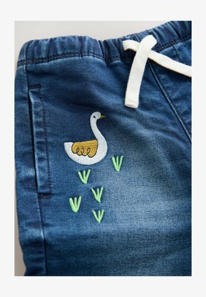 Shorts in denim con vita elastica e cordoncino bianco, caratterizzati da un'anatra ricamata bianca e dettagli in erba verde sulla gamba.