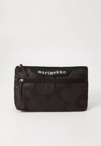 Marimekon musta kangaspussi sävykkäällä abstraktilla kuviolla, jossa on kaksi vetoketjullista osastoa ja valkoinen logo yläosassa. Suorakaiteen muotoinen.