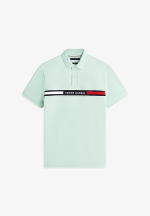 Polo verde chiaro a maniche corte con colletto, due bottoni e una striscia orizzontale nera, bianca e rossa sul petto con la scritta "Tommy Hilfiger".