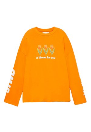 Fel oranje shirt met lange mouwen met drie illustraties van tulpen en de tekst "Een bloei voor jou" op de voorkant, witte tekst op de mouwen.