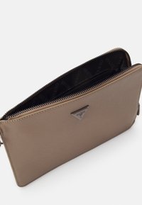 Brązowa syntetyczna kopertówka o gładkiej teksturze, z zamkiem i akcentem w postaci logo. Wewnątrz znajduje się czarna podszewka w wzory. Kompaktowy, prostokątny kształt.