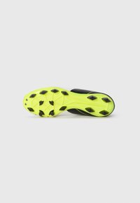 Black and white soccer cleat sole with bright yellow accents, featuring molded rubber studs for traction on grass surfaces.