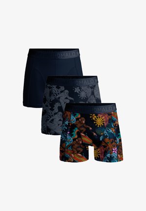 Tres calzoncillos tipo bóxer apilados; uno negro sólido, otro negro con monos grises surfeando, y otro con monos coloridos surfeando junto con patrones de pulpo y sol.