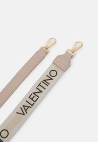 Λουράκι Valentino με μπεζ δέρμα και μια γκρι υφασμάτινη ενότητα που φέρει μεγάλα μαύρα γράμματα. Χρυσής απόχρωσης μεταλλικά αξεσουάρ με περιστρεφόμενους γάντζους.