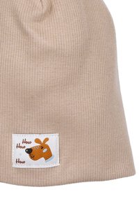 Beige neulottu pipo, jossa on raunioitettu pinta. Pipo sisältää valkoisen tarran, jossa on oranssi koira-karonkuva ja teksti "How How How."