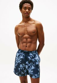 Blaue Blumenschwimmshorts mit einem gemusterten Design, elastischem Bund und Seitentaschen, ausgestattet mit einem glatten, leichten Stoff.