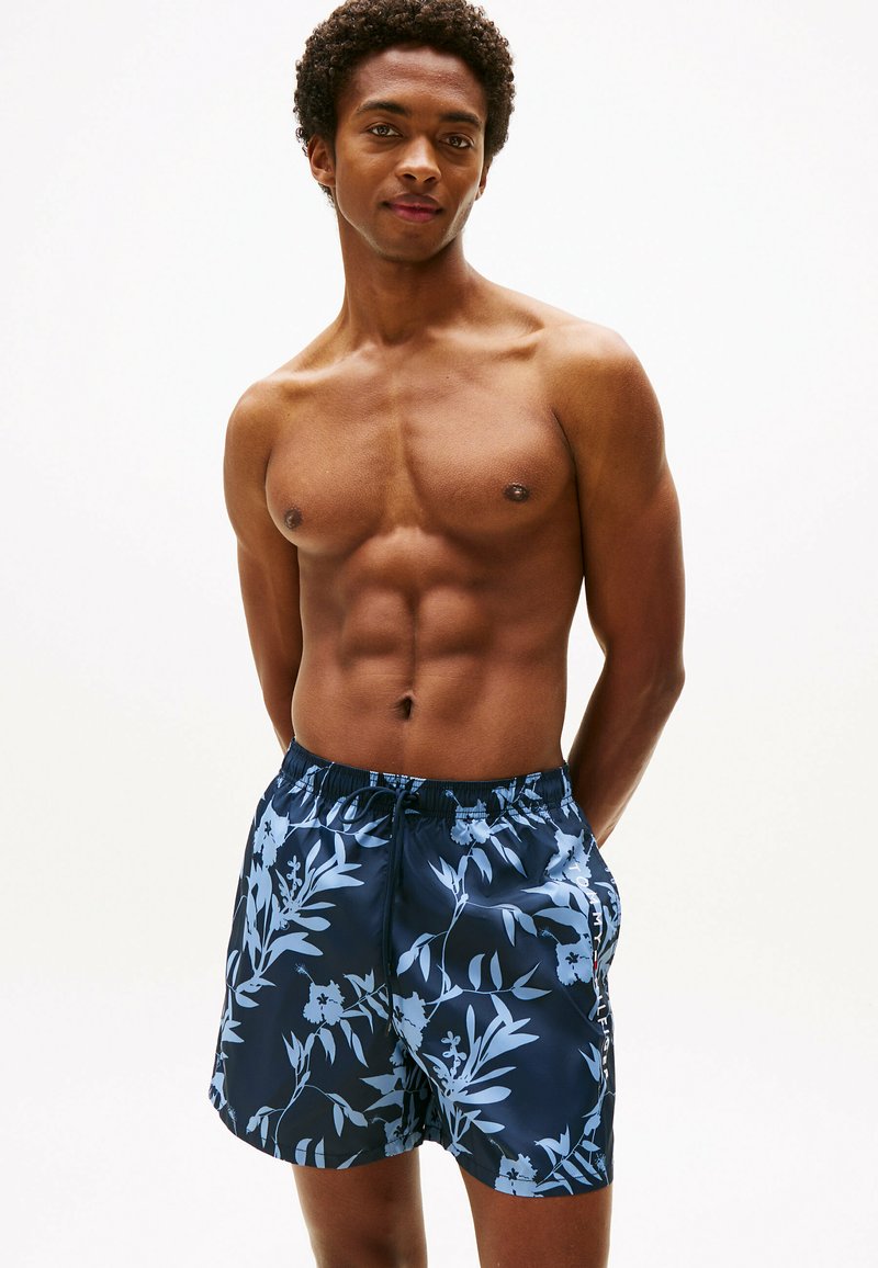 Blaue Blumenschwimmshorts mit einem gemusterten Design, elastischem Bund und Seitentaschen, ausgestattet mit einem glatten, leichten Stoff.