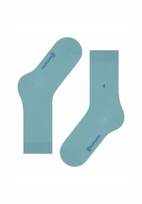 Des chaussettes turquoise présentées à plat, dont l'une arbore un clou en argent. Les deux ont un logo de marque bleu sur le côté.