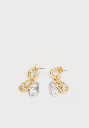 Gold and silver earrings with heart-shaped accents and a clear gem detail, featuring a circular hoop design and layered charm elements.