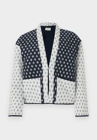 Quilted jacket with a navy and white pattern, featuring a deep V-neck, long sleeves, and two front pockets. Elegant contrasting edges.