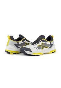Scarpe sportive con una combinazione di colori bianco, grigio e giallo. Presentano una tomaia in mesh, suola in gomma testurizzata e un evidente logo 'X' giallo.