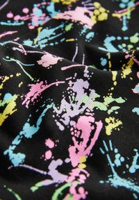 Baumwollstoff mit schwarzem Hintergrund, der ein lebhaftes Spritzmuster in Pastellfarben wie Pink, Blau, Gelb und Grün zeigt.