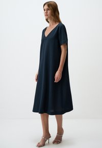 Navy-blaues A-Linien-Kleid mit V-Ausschnitt, kurzen Ärmeln und lockerer Passform. Hergestellt aus weichem, strukturiertem Stoff, endet es unterhalb der Knie.