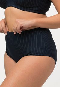 Hoge taille bikini-onderstuk in marineblauw met gouden streepjes. Heeft geschulpte randen en een soepele, rekbare stof voor een comfortabele pasvorm.