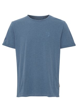 T-shirt en coton bleu avec un col rond, des manches courtes et un petit logo brodé sur le côté gauche. Texture douce, coupe décontractée.
