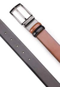 Odwracalny skórzany pasek: z jednej strony gładki czarny, z drugiej brązowy z subtelnym połyskiem, wyposażony w srebrną metalową sprzączkę z wytłoczonym logo.