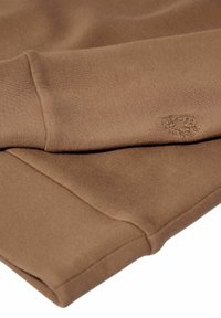 Felpa marrone con una texture liscia, polsini a coste e un piccolo logo impresso sul maniche.