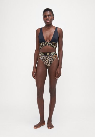 Svart badedrakt med dyp V-hals, gullfarget gresk nøkkelmotiv i midjen og leopardmønstret bunn. Jevn tekstur, stilfull snitt.