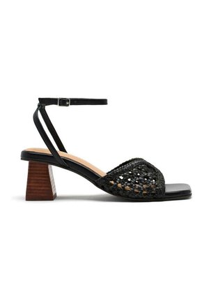 Sandale noire à talons avec dessus tissé, bout ouvert et bride de cheville. Talon bloc avec une texture bois. Semelle intérieure noire lisse.