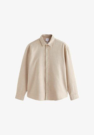 Chemise beige à boutons, fabriquée en tissu texturé, dotée d'un col, de manches longues et d'une patte de boutonnage à l'avant avec des boutons clairs.