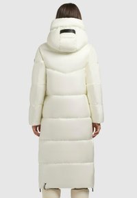 Lang hvid puffjakke med hætte, med et quiltet design, glat tekstur og en lynlåsåbning i kanten. Sort detalje på hætten.