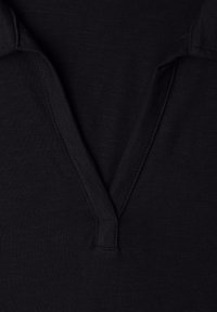 Tissu noir avec un col en V et un détail de col, montrant une couture fine et une texture.