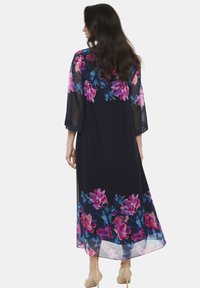 Długa, granatowa sukienka w kwiatowy wzór w odcieniach różu i niebieskiego. Przezroczyste rękawy i dół z lekką przejrzystością. Długość do podłogi, luźny fason.